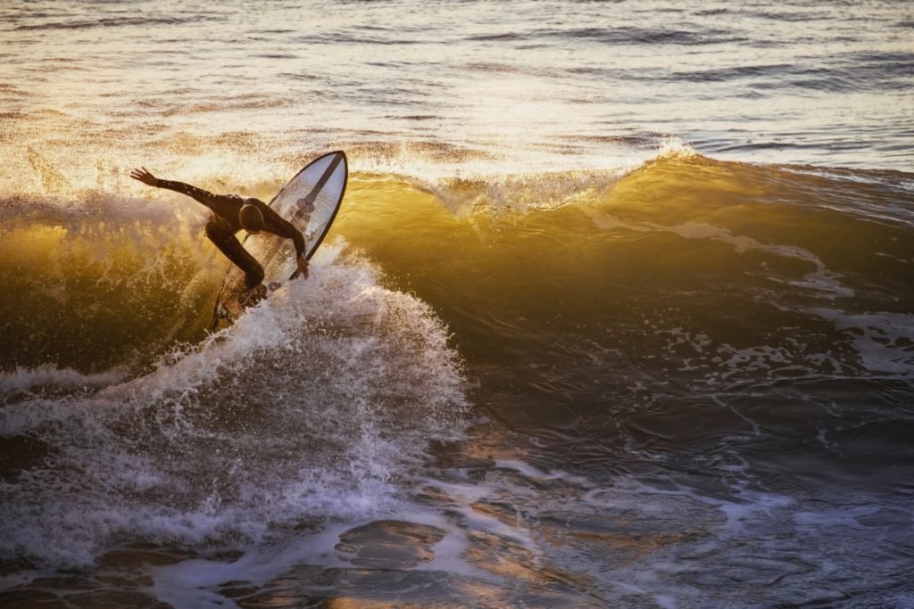 man surfing on sea waves during daytime